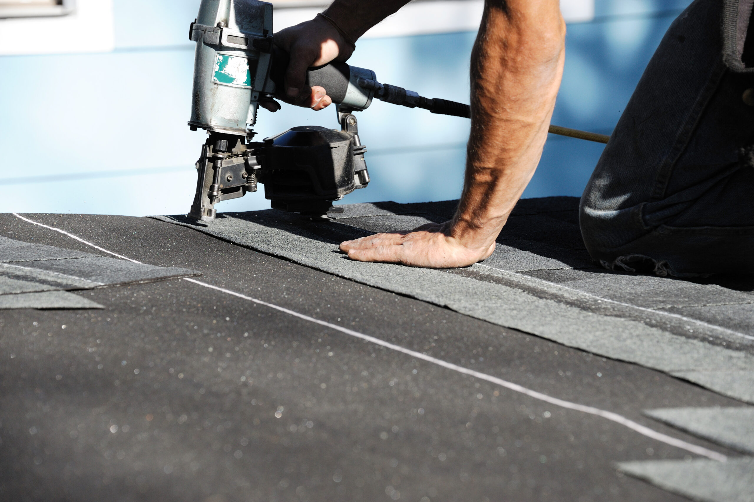 Roofer shingling a residential roof in Kentucky